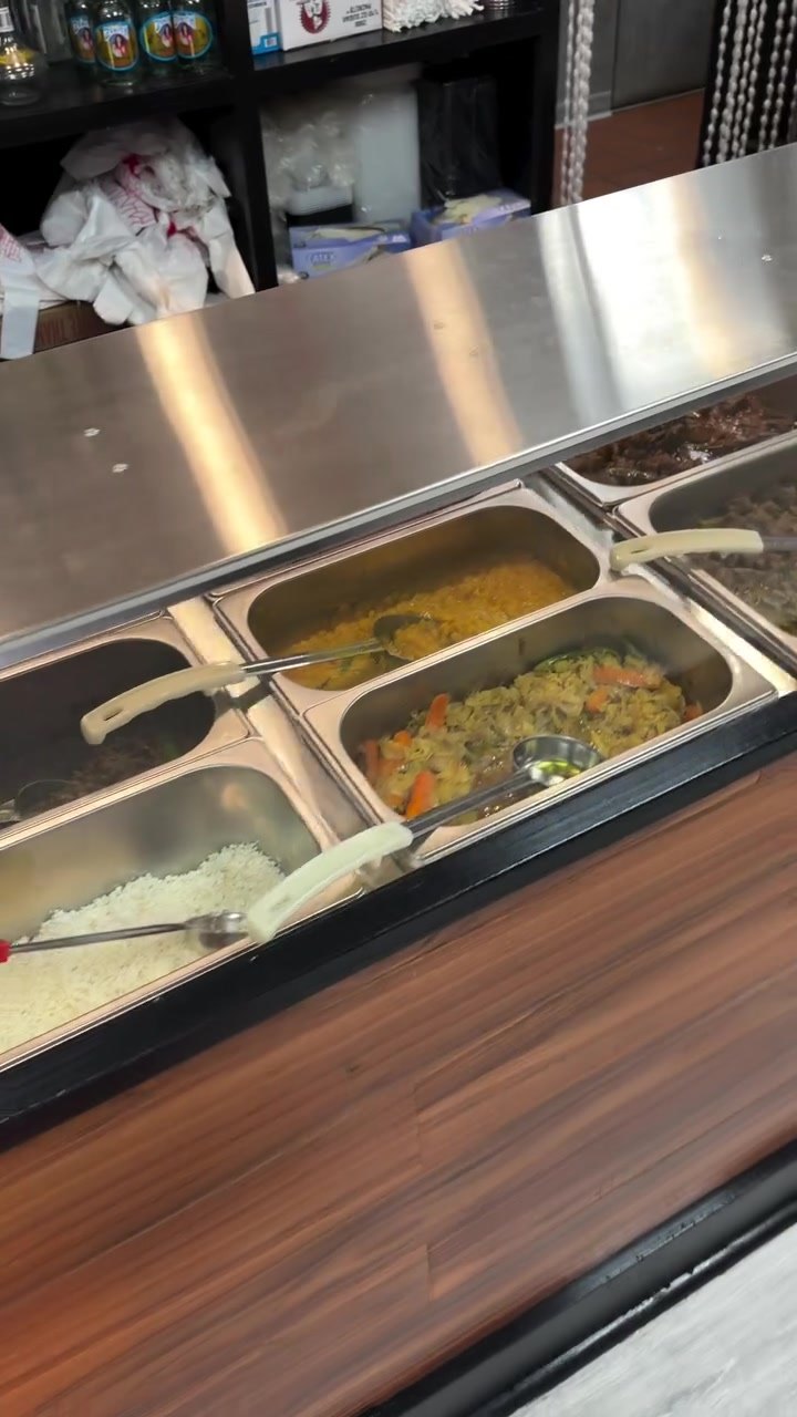 Steam table with the Habesha buffet: lentils, greens, vegetables and stews